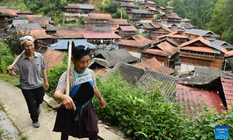 Villager Liang Yingmi (L) and his wife Liang Anhe go to work in Wuying Village on the border between south China's Guangxi Zhuang Autonomous Region and southwest China's Guizhou Province, July 18, 2024. Wuying Village, spanning a history of over 200 years, is a Miao ethnic group hamlet that nestles snugly in the towering mountains stretching across the border between Guangxi and Guizhou. (Photo: Xinhua)