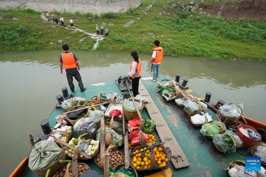 Cao Lifang (C) and other crew members prepare to help passengers get on board at a stop of the route of Yu Zhong Ke 2180 ferry in southwest China's Chongqing Municipality, July 10, 2024. (Photo: Xinhua)