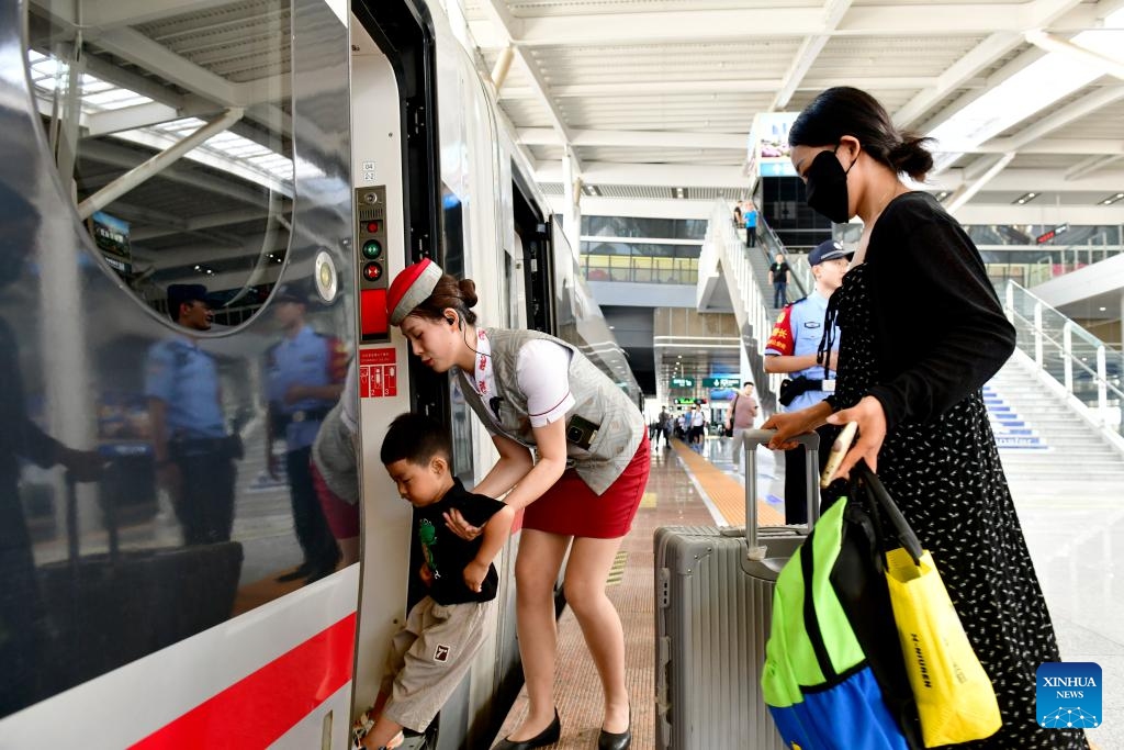 A staff member helps a child board the bullet train G4007 from Heze to Zhengzhou at Heze East Railway Station in Heze City, east China's Shandong Province, July 18, 2024. The section from Zhuangzhai in east China's Shandong Province to Lankao in central China's Henan Province was put into service on Thursday, marking the full operation of the 472-kilometer-long Rizhao-Lankao high-speed railway. (Photo: Xinhua)