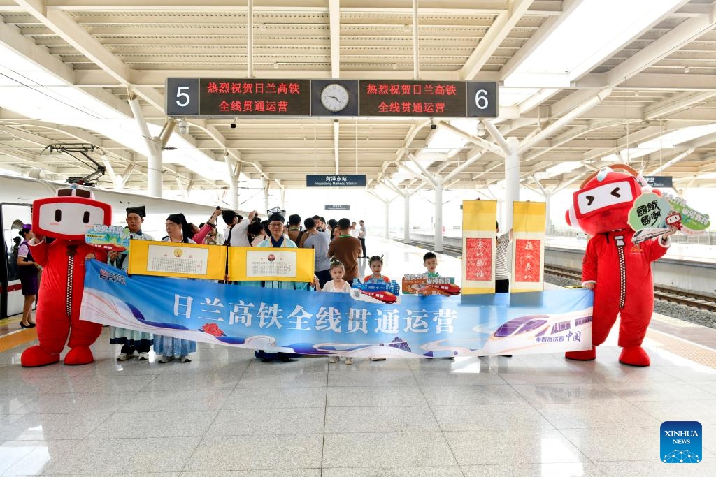 People pose for a photo to celebrate the full operation of the Rizhao-Lankao high-speed railway at Heze East Railway Station in Heze City, east China's Shandong Province, July 18, 2024. The section from Zhuangzhai in east China's Shandong Province to Lankao in central China's Henan Province was put into service on Thursday, marking the full operation of the 472-kilometer-long Rizhao-Lankao high-speed railway. (Photo: Xinhua)