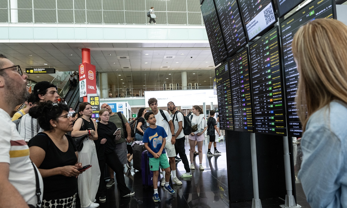 Passengers look at a screen displaying delayed flights at Barcelona Airport on July 19,<strong></strong> 2024 in Barcelona, Spain. Businesses, travel companies and Microsoft users across the globe were among those affected by a tech outage today. Photo: VCG