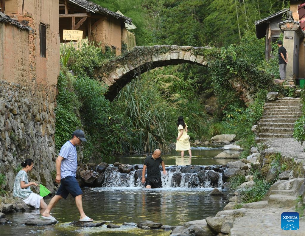 Tourists visit Songzhuang Village in Songyang County, east China's Zhejiang Province, July 17, 2024. Nestled in the mountains, Songzhuang Village of Songyang County boasts a history of over 600 years and preserves many traditional residences. In recent years, local government has renovated old houses and ancient paths and introduced new business forms to attract young talents to start their businesses there. (Photo: Xinhua)