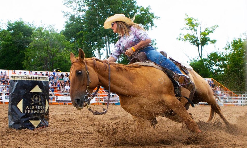 A cowgirl competes in the barrel racing event at the 2024 RAM Rodeo Tour in Erin, Ontario, Canada, on July 21, 2024. (Photo by Zou Zheng/Xinhua)