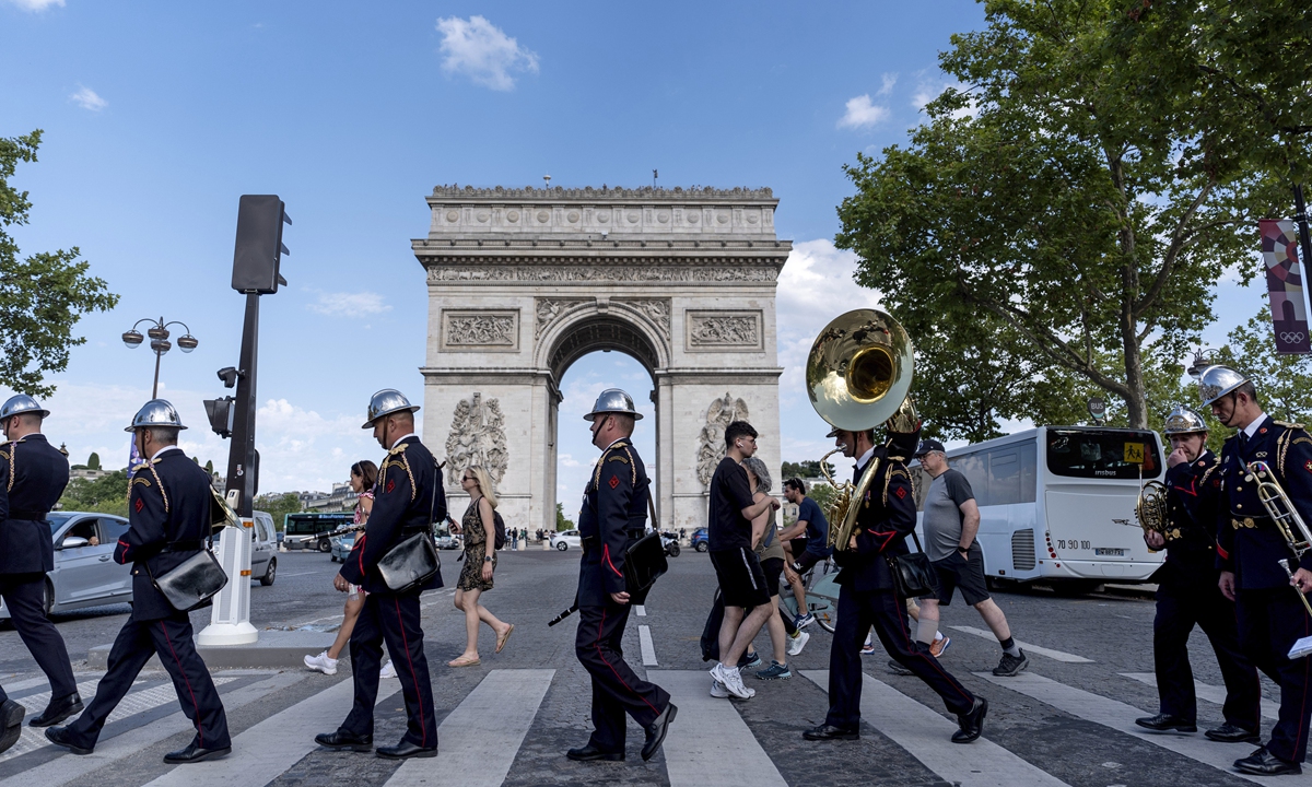 Members of a fire brigade band cross the street in front of the Arc de Triomphe in Paris on July 20, 2024, as the city is getting ready for the 2024 Summer Olympics. Photo: VCG