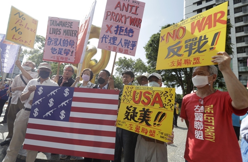 Protesters hold posters in Taipei, the island of Taiwan during the so-called Taiwan-US Defense Industry Forum, on May 3, 2023. Photo: VCG