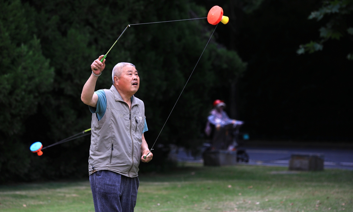 An elderly man spins a traditional kongzhu, also known as a diabolo, in a park in Huaian, East China's Jiangsu Province, on June 2, 2024. Photo: VCG