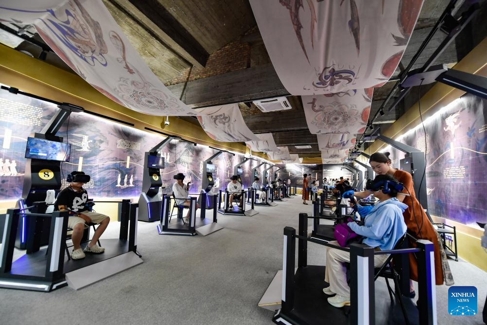 Visitors use virtual reality (VR) equipment to visit the Mogao Grottoes in Dunhuang, northwest China's Gansu Province, July 22, 2024. A digital exhibition utilizing technologies as 3D modeling and VR devices is held to help visitors have an immersive impression of the culture of Dunhuang. (Photo: Xinhua)