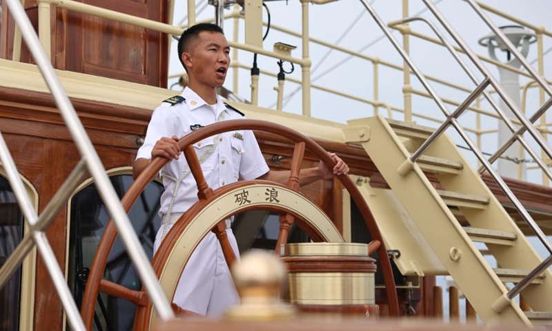 A steersman of the Chinese People's Liberation Army (PLA) Navy demonstrates steering for military attachés aboard a training vessel, July 22, 2024.(Photo: Xinhua)