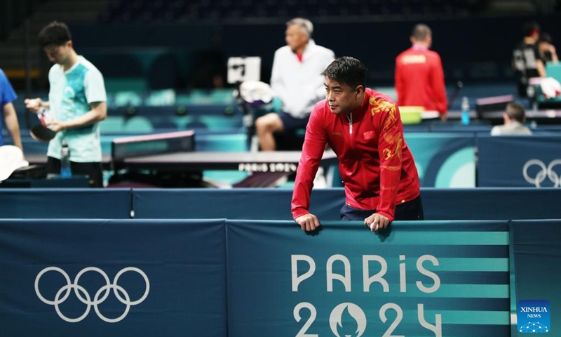 Wang Hao, coach of the Chinese national table tennis team, looks on during a training session for Paris 2024 in South Paris Arena, Paris, France, July 22, 2024. (Xinhua/Wang Dongzhen)