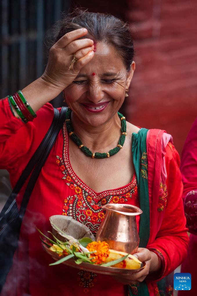 A woman puts tika on the forehead following a worship ritual on the first Monday of the holy month of Shrawan in Lalitpur, Nepal, on July 22, 2024. (Photo: Xinhua)