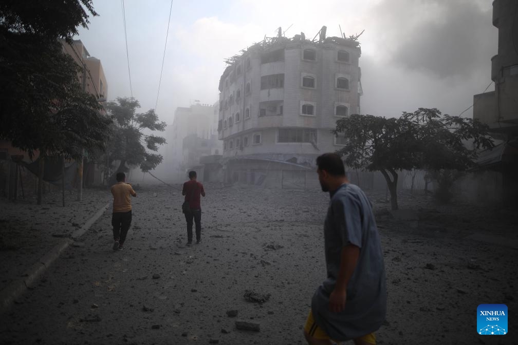 Palestinians walk past a destroyed residential apartment after an Israeli airstrike in the Nuseirat refugee camp in central Gaza, July 21, 2024. The Israeli army has bombed the central Gazan refugee camp of Nuseirat 63 times in seven days, killing 91 Palestinians and injuring 251 others, the Hamas-run Gaza government media office said Sunday. (Photo: Xinhua)