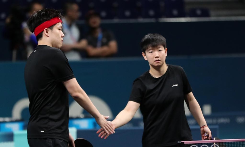 Wang Chuqin/Sun Yingsha (R) of the Chinese national table tennis team react during a training session for Paris 2024 in South Paris Arena, Paris, France, July 22, 2024. (Xinhua/Wang Dongzhen)