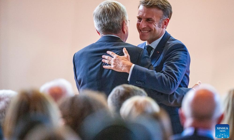 French President Emmanuel Macron (R) hugs IOC President Thomas Bach during the 142nd IOC Session Opening Ceremony at the Louis Vuitton Foundation in Paris, France on July 22, 2024. (Xinhua/Sun Fei)