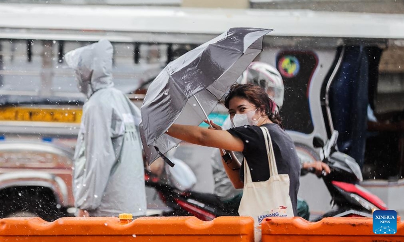 A woman uses an umbrella to avoid the heavy rain brought by typhoon Gaemi in Quezon City, the Philippines, July 22, 2024. (Photo: Xinhua)