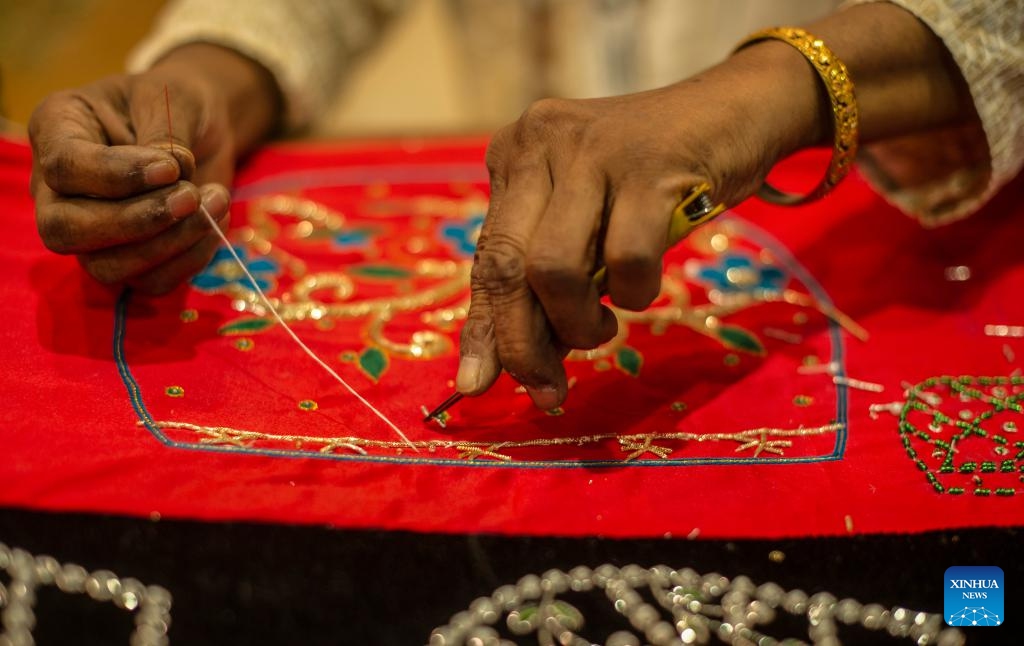 An Indian artisan works on clothes using Zardozi embroidery at an exhibition titled Incredible India in New Delhi, India, July 22, 2024. The exhibition is set up to highlight India's rich cultural heritage, age-old civilization, geographical diversity, and tourism destinations (Photo: Xinhua)