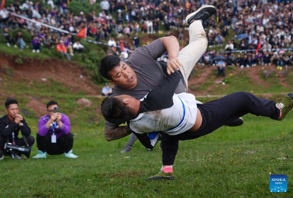 People wrestle during a torch festival in Eliping Township, Butuo County, southwest China's Sichuan Province, July 21, 2024. From July 21 to 23, a traditional torch festival of Yi ethnic group was held in Butuo County. People participated in various folk sports events such as horse racing, sheepfighting, bullfighting and wrestling during the festival. (Photo: Xinhua)