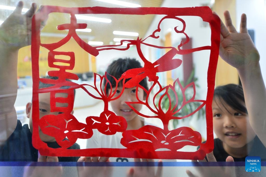 Children display a paper-cutting work at Yinchuan West Road Community of Shinan District, Qingdao, east China's Shandong Province, July 22, 2024. During the summer vacation, the community organized activities of learning intangible cultural heritage to enrich children's holiday experience. (Photo: Xinhua)