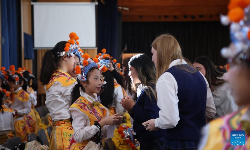 Members of China's Guangzhou Opera House Children's Choir talk with students of Wellington East Girls' College in Wellington, New Zealand, July 24, 2024. Members of Guangzhou Opera House Children's Choir visited Wellington East Girls' College in New Zealand on Wednesday, and held a joint concert with the high school's choir at the opening ceremony of the new semester of the school. (Photo: Xinhua)