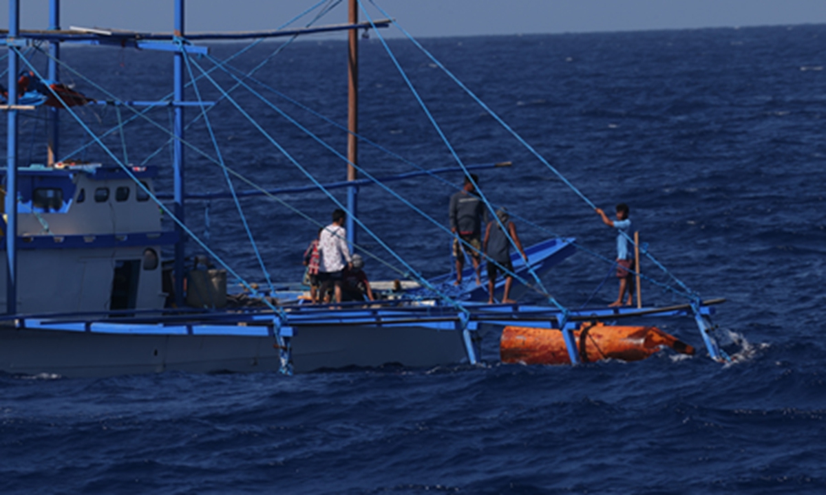 A Philippine fishing vessel places an illegal fish-collecting device in the waters of Houteng Jiao in the South China Sea. Photo: Fan Wei/GT