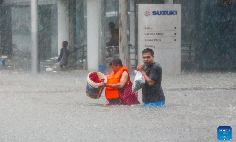 Residents wade through floodwater in Quezon City, the Philippines, on July 24, 2024. The Philippines has been buffeted by non-stop rains from the enhanced southwest monsoon brought by Typhoon Gaemi, which caused the Metro Manila Council to declare a state of calamity in National Capital Region on Wednesday. (Photo: Xinhua)