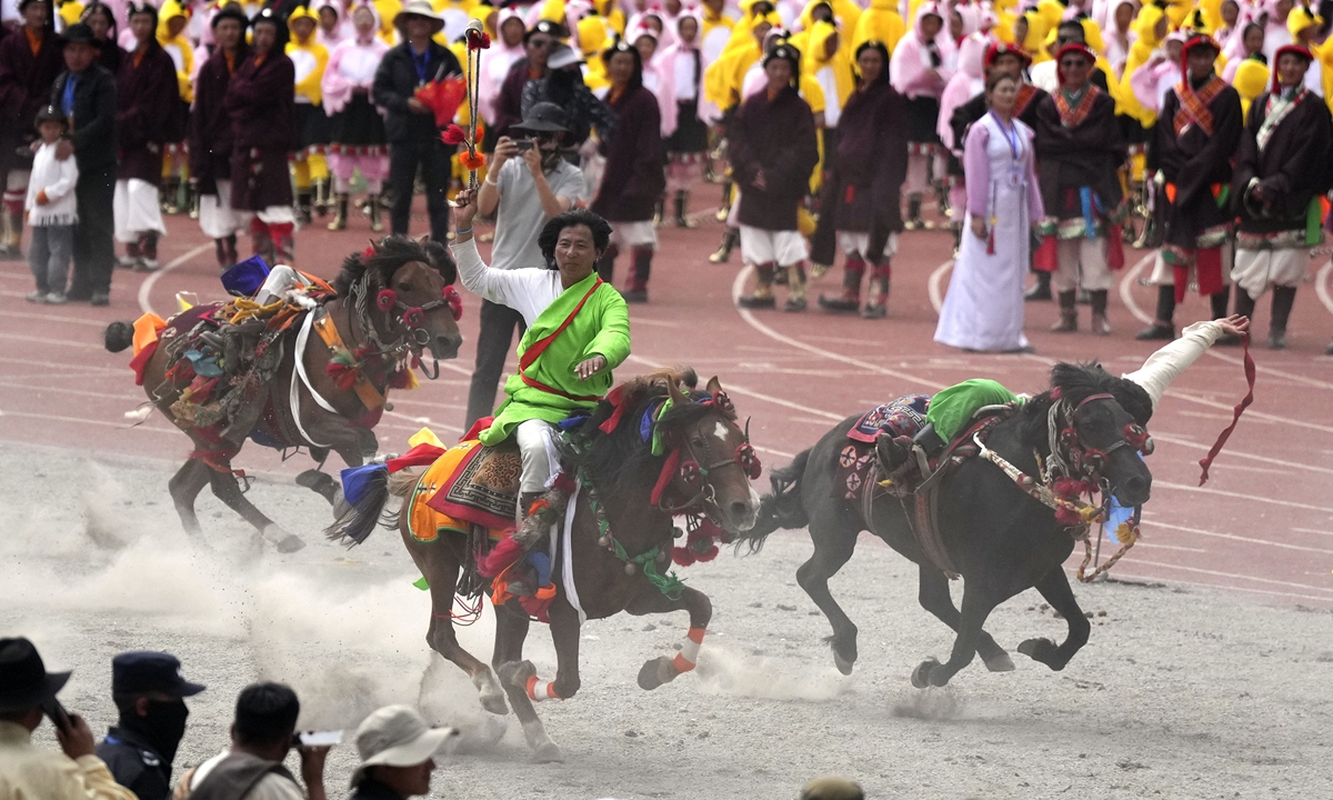 Horse riders perform during the opening ceremony of a culture and tourism festival in Yushu, Northwest China's Qinghai Province, on July 25, 2024. The event featured over 7,000 participants and 700 horses, transforming the green racetrack into a lively ocean of singing and dancing. Photo: VCG