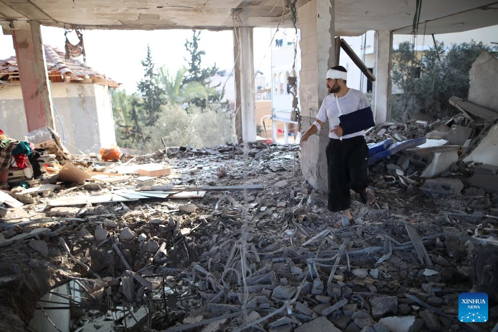 An injured Palestinian man checks a building destroyed in an Israeli airstrike, in Deir al-Balah refugee camp in central Gaza Strip, on July 23, 2024. (Photo: Xinhua)