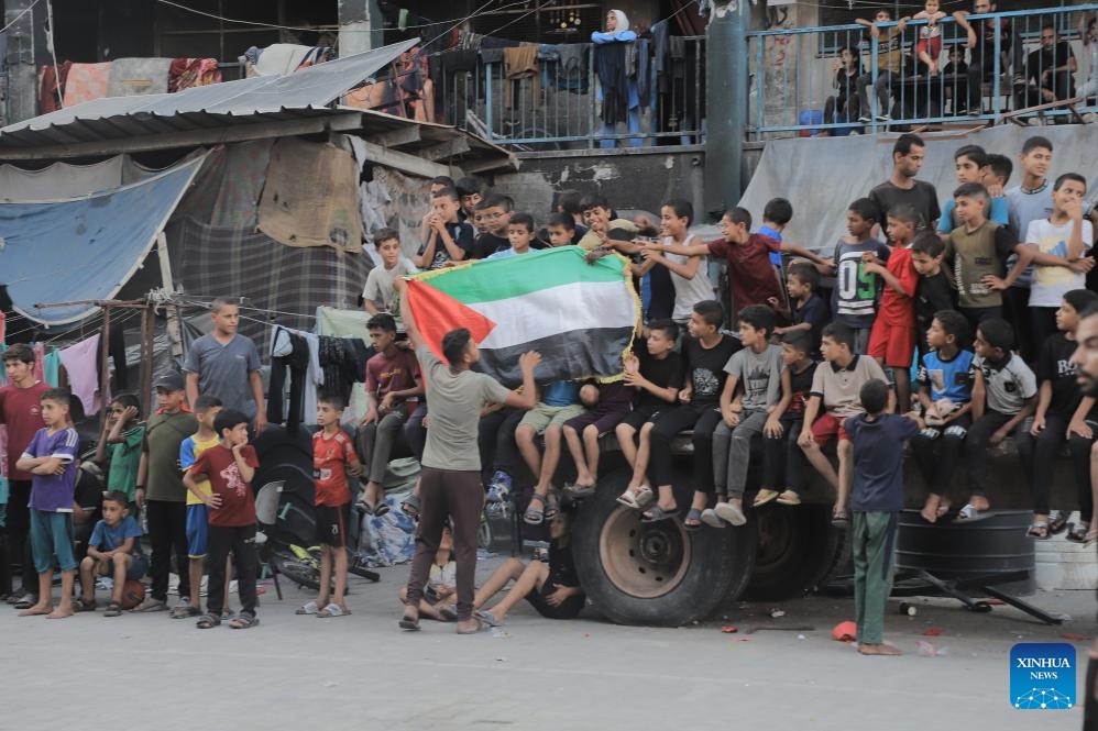 People watch a football game in Jabalia refugee camp, northern Gaza Strip, on July 23, 2024. (Photo: Xinhua)