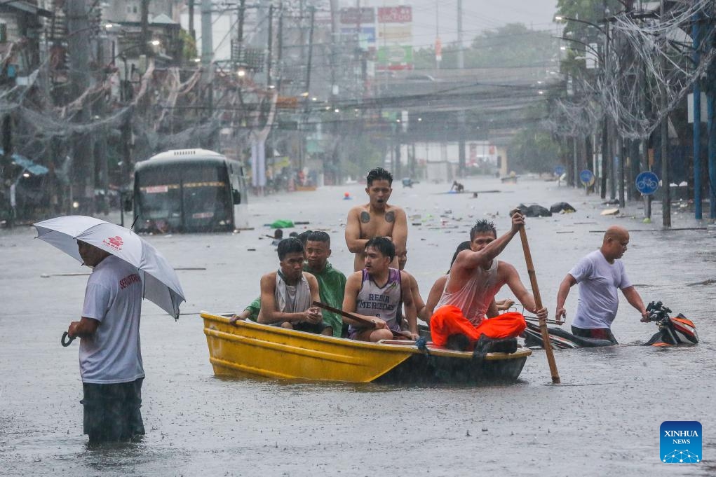 Residents row a boat on a flooded street in Quezon City, the Philippines, on July 24, 2024. The Philippines has been buffeted by non-stop rains from the enhanced southwest monsoon brought by Typhoon Gaemi, which caused the Metro Manila Council to declare a state of calamity in National Capital Region on Wednesday. (Photo: Xinhua)