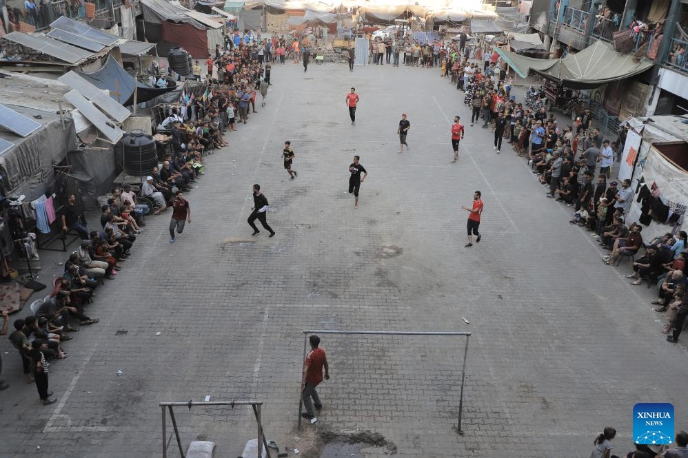 This photo taken on July 23, 2024 shows people playing a football game in Jabalia refugee camp, northern Gaza Strip. (Photo: Xinhua)