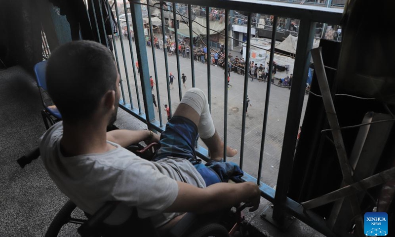 A man watches a football game in Jabalia refugee camp, northern Gaza Strip, on July 23, 2024. (Photo: Xinhua)