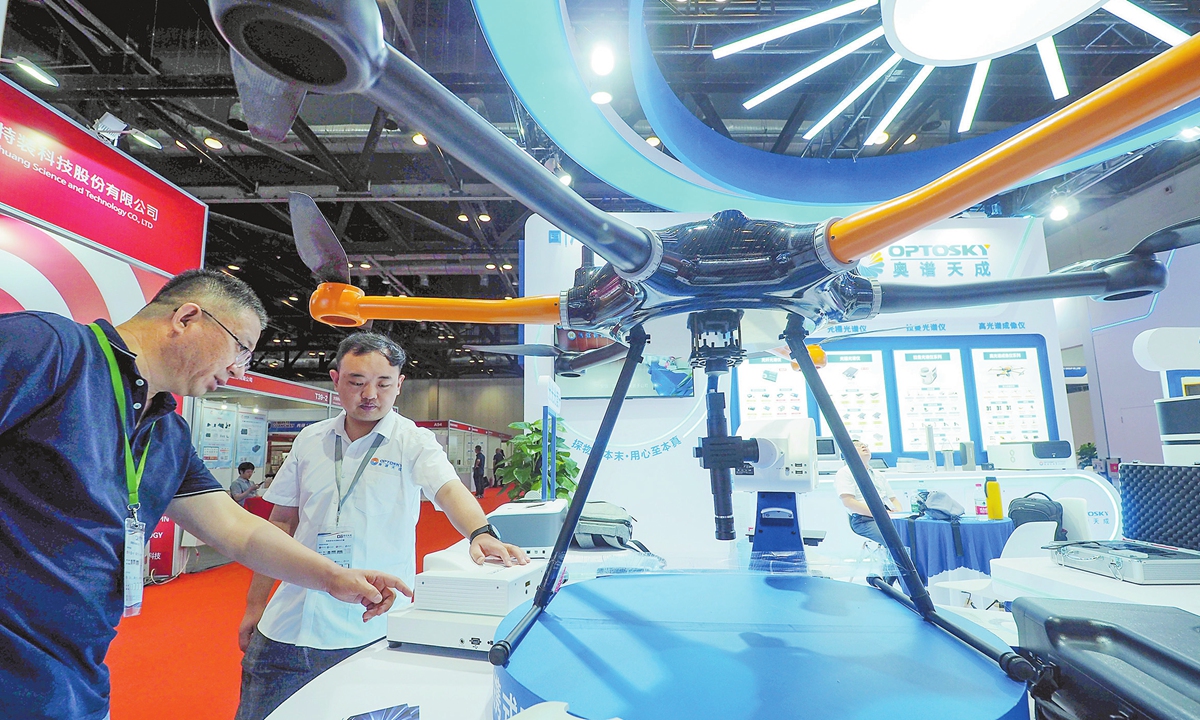 Two visitors look at a hyperspectral imager on an unmanned aircraft at the World Photonics Congress 2024 in Beijing on July 25, 2024. The four-day conference focuses on the innovation and development of photonics technologies, including lasers, infrared  equipment as well as measurement and control technologies. Photo: VCG