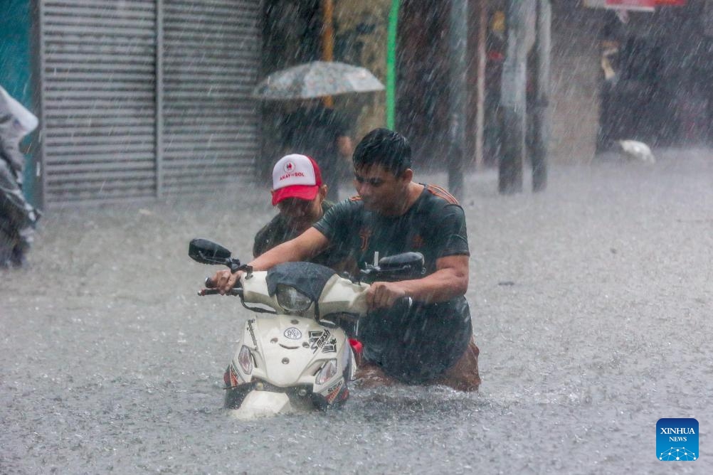 Residents wade through floodwater in Quezon City, the Philippines, on July 24, 2024. The Philippines has been buffeted by non-stop rains from the enhanced southwest monsoon brought by Typhoon Gaemi, which caused the Metro Manila Council to declare a state of calamity in National Capital Region on Wednesday. (Photo: Xinhua)