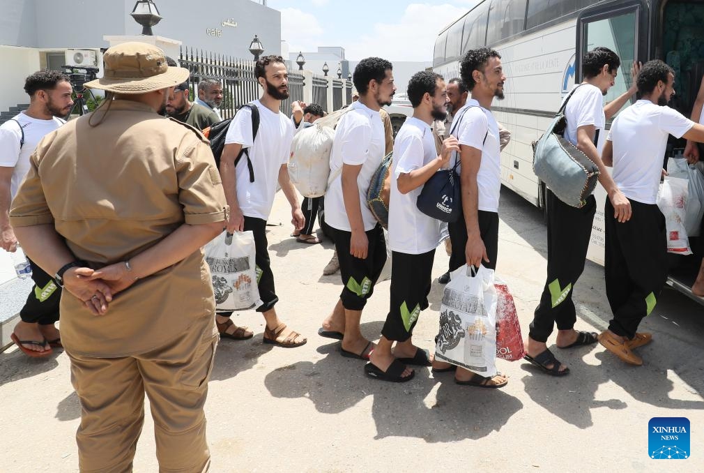 Migrants line up to get on a bus outside the Deportation Office of the Libyan Illegal Immigration Control Department in Tripoli, Libya, on July 25, 2024. The Illegal Migration Control Department of Libya on Thursday deported more than 700 illegal migrants to their home countries of Niger and Egypt, an official told Xinhua. (Photo: Xinhua)