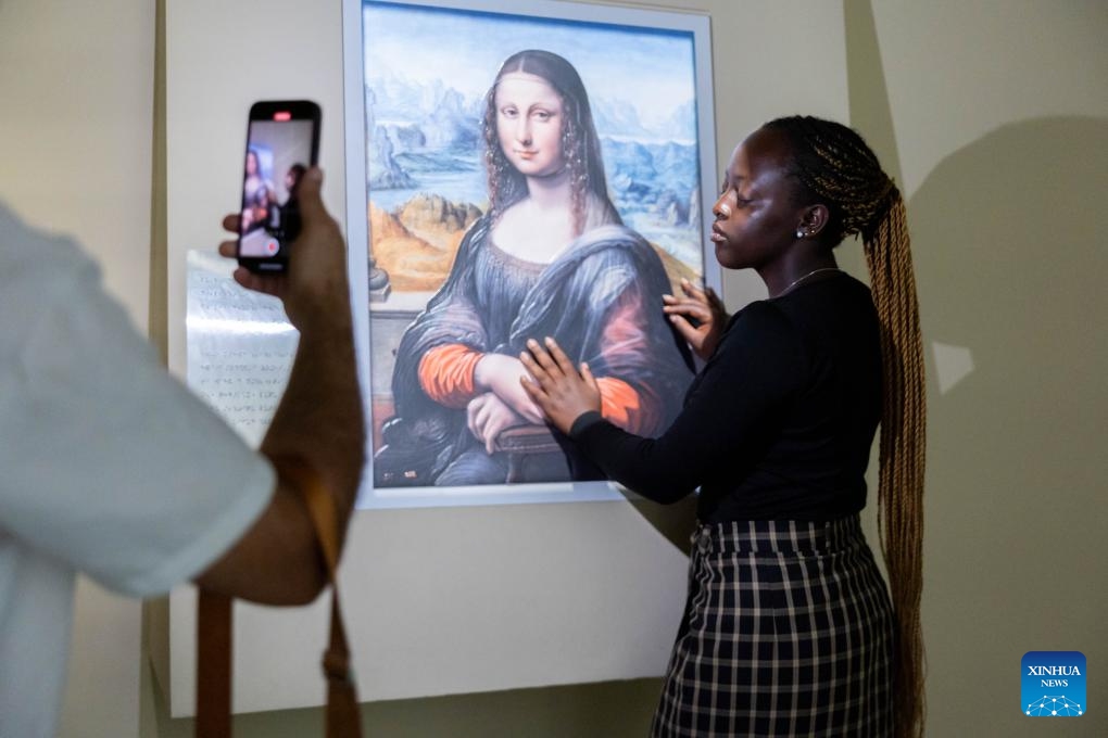 An internet celebrity touches the touchable version of Mona Lisa at Museum of Art Pudong in east China's Shanghai, July 24, 2024. Internet celebrities from 21 countries as Brazil, India, Malaysia and Mexico, came to Shanghai for a visit where they can witness the daily lives in China. (Photo: Xinhua)