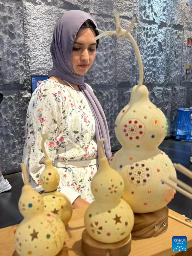 An internet celebrity looks at intangible cultural heritage crafts at Shanghai Tower in east China's Shanghai, July 24, 2024. Internet celebrities from 21 countries as Brazil, India, Malaysia and Mexico, came to Shanghai for a visit where they can witness the daily lives in China. (Photo: Xinhua)