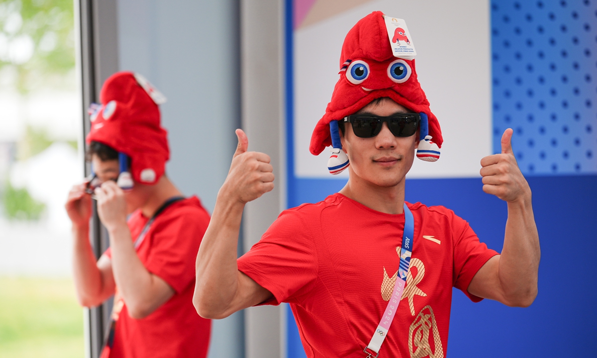 Chinese diver Yang Hao wears a souvenir of the Paris Olympics mascot Phryge at a souvenir shop in the Olympic Village in Paris on July 21, 2024.