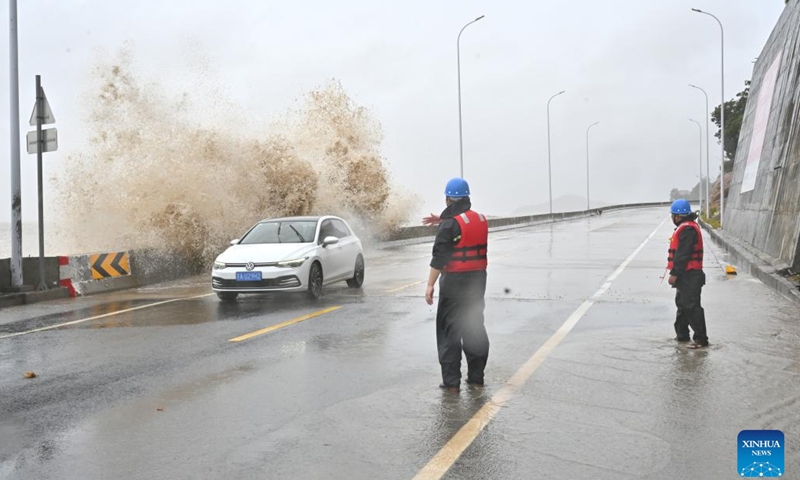 Emergency staff members guide a stranded car to a safe area as huge waves lash the shore in Sansha Township of Xiapu County, southeast China's Fujian Province, July 25, 2024. East China's Fujian Province had relocated 156,800 residents as of 7 a.m. Thursday as Typhoon Gaemi, the third typhoon of this year, approaches, said local authorities. Meanwhile, 73 passenger ferry routes along the province's coast were suspended and 97 flights canceled. (Photo: Xinhua)