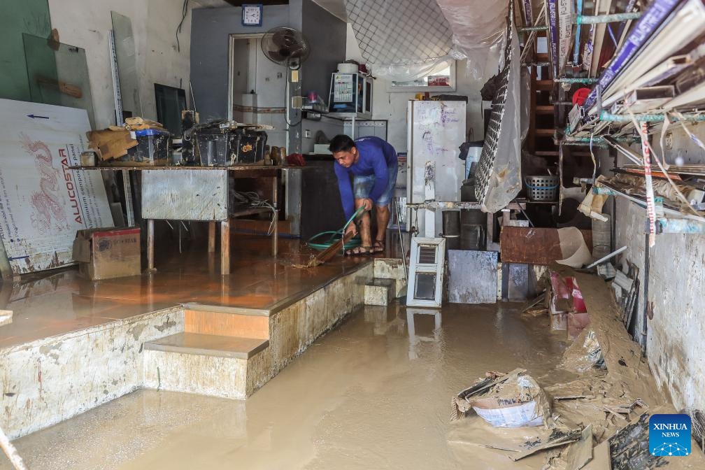 A resident cleans silts brought by floods at home in Marikina City, the Philippines, July 25, 2024. Reported deaths from heavy rains, massive flooding, and landslides triggered by southwest monsoon enhanced by typhoon Gaemi have climbed to 21, police said on Thursday. (Photo: Xinhua)