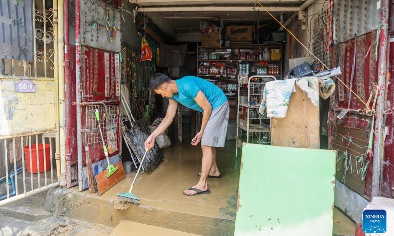 A resident cleans silts brought by floods in Marikina City, the Philippines, July 25, 2024. Reported deaths from heavy rains, massive flooding, and landslides triggered by southwest monsoon enhanced by typhoon Gaemi have climbed to 21, police said on Thursday. (Photo: Xinhua)