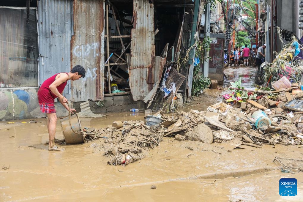 A resident cleans garbages brought by floods in Marikina City, the Philippines, July 25, 2024. Reported deaths from heavy rains, massive flooding, and landslides triggered by southwest monsoon enhanced by typhoon Gaemi have climbed to 21, police said on Thursday. (Photo: Xinhua)