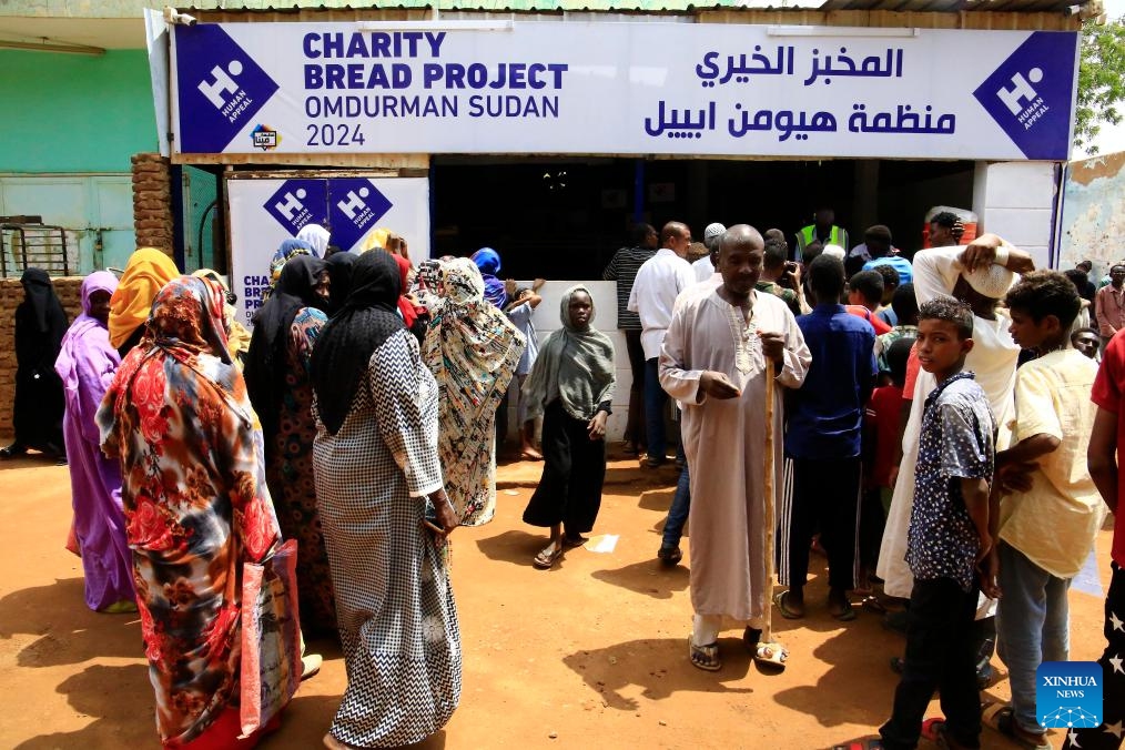 People line up to receive free bread in front of a charity bakery in Omdurman city, Sudan, July 24, 2024. The Charity Bread Project has recently been launched by the Human Appeal, a non-profit organization, to distribute free bread for people in need in Omdurman city. (Photo: Xinhua)