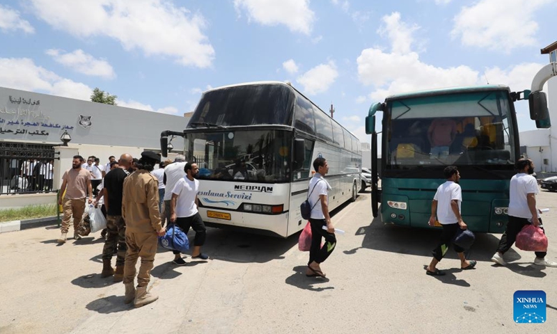 Migrants line up to get on a bus outside the Deportation Office of the Libyan Illegal Immigration Control Department in Tripoli, Libya, on July 25, 2024. The Illegal Migration Control Department of Libya on Thursday deported more than 700 illegal migrants to their home countries of Niger and Egypt, an official told Xinhua. (Photo: Xinhua)