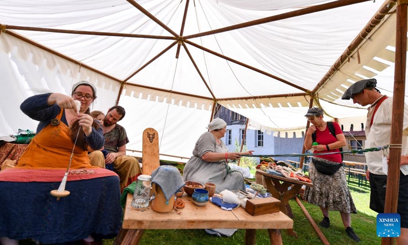 People demonstrate traditional weaving during the folk festival Mittelalter-Spektakel at Munchenwiler Castle in the Lake Murten region in Switzerland, July 27, 2024. The folk festival was held from Friday to Sunday at Munchenwiler Castle. Various activities, fairs, and folk performances featuring the Middle Ages were organized during the festival. Photo: Xinhua