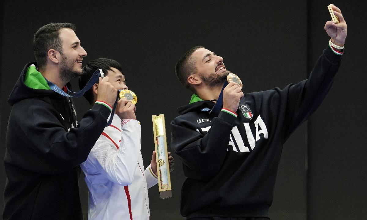 Chinese shooter Xie Yu (center), who won a gold medal in the men's 10-meter air pistol final, poses for a selfie with silver medalist Frederico Nilo Maldini of Italy (left) and bronze medalist Paolo Monna of Italy on the podium at the Paris Olympics on July 28, 2024. It is the 24-year-old Chinese shooter's Olympic debut. Photo: VCG