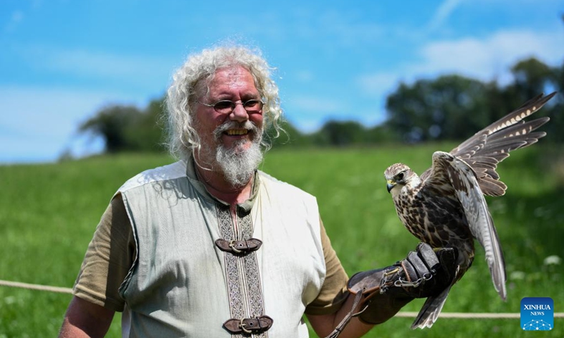 A man in folk costume demonstrates falconry during the folk festival Mittelalter-Spektakel at Munchenwiler Castle in the Lake Murten region in Switzerland, July 27, 2024. The folk festival was held from Friday to Sunday at Munchenwiler Castle. Various activities, fairs, and folk performances featuring the Middle Ages were organized during the festival. Photo: Xinhua