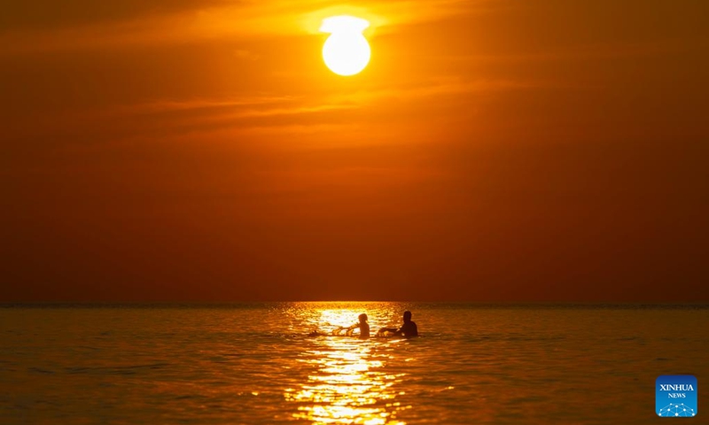 People play in Lake Huron during sunset at Pinery Provincial Park in Ontario, Canada, on July 28, 2024. Photo: Xinhua