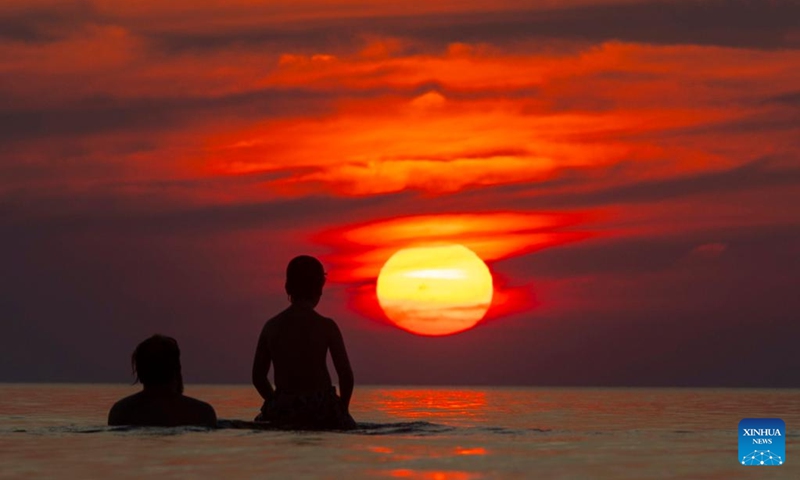 People view the sunset in Lake Huron during sunset at Pinery Provincial Park in Ontario, Canada, on July 28, 2024. Photo: Xinhua