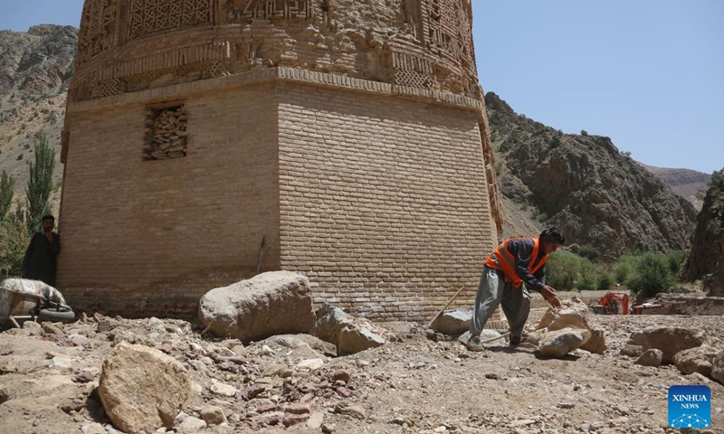 A worker clears stones after a flood near the Minaret of Jam in the Shahrak District, central Afghanistan's Ghor Province, July 28, 2024. The Minaret of Jam, along with its archaeological remains, was inscribed on the World Heritage List by the United Nations Educational, Scientific and Cultural Organization (UNESCO) in 2002. In May, a huge flood hit the province, posing a threat to the minaret, which stands near the Hari River. Photo: Xinhua