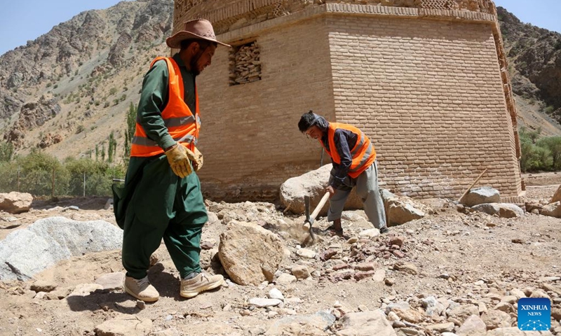 Workers clear stones after a flood near the Minaret of Jam in the Shahrak District, central Afghanistan's Ghor Province, July 28, 2024. The Minaret of Jam, along with its archaeological remains, was inscribed on the World Heritage List by the United Nations Educational, Scientific and Cultural Organization (UNESCO) in 2002. In May, a huge flood hit the province, posing a threat to the minaret, which stands near the Hari River. Photo: Xinhua