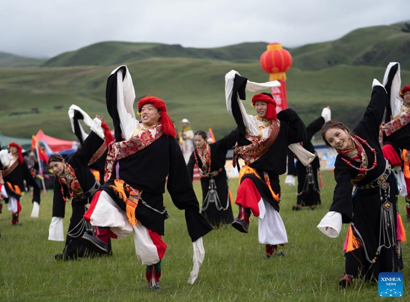 Locals perform Guozhuang dance on a grassland in Baiyu County, Garze Tibetan Autonomous Prefecture, southwest China's Sichuan Province, July 27, 2024. A rural folk event kicked off here on Saturday, consisting of performances, milking competition, yak beauty contest, horse racing and other activities. Photo: Xinhua